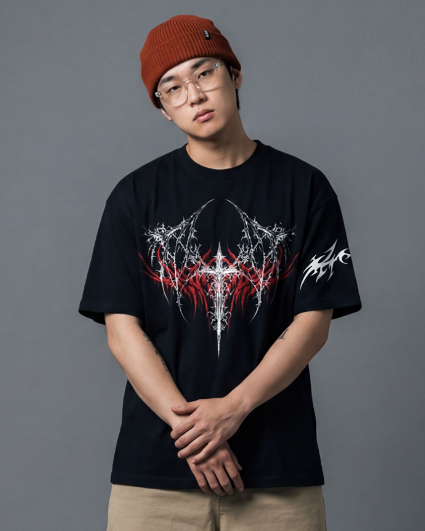 Person wearing a black t-shirt with a graphic design, beige shorts, and a red beanie on a gray background