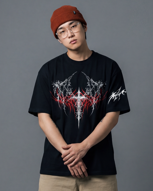 Person wearing a black t-shirt with a graphic design, beige shorts, and a red beanie on a gray background