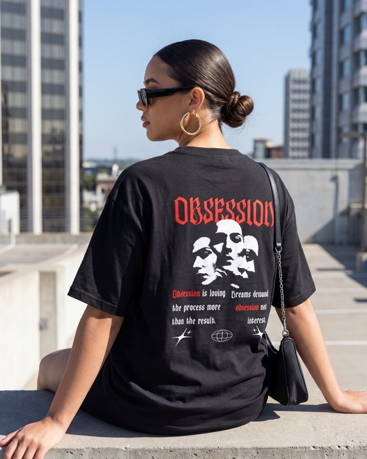 Person wearing a black t-shirt with graphic design and text on a rooftop with cityscape background