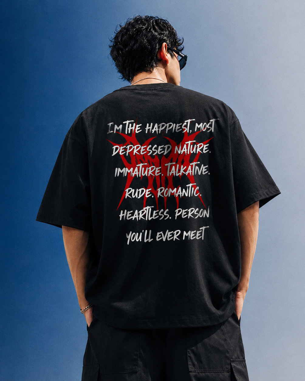 Person wearing a black t-shirt with text on the back against a blue and gray gradient background